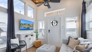 A living room with a television, a sofa, a chair, and a ceiling fan. - TXFirefly88 | Two Porches, Picnic Table (Fredericksburg)
