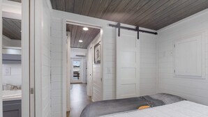 A bedroom with a bed, a dresser, and a walk-in closet. - Then Sings My Soul | Covered Porch & Fireplace! (Fredericksburg)