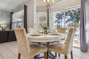Un comedor con una mesa redonda, seis sillas y vistas al exterior.