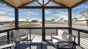 A covered outdoor seating area with a view of a road and buildings. - Tiny Treasure | 1.5 Baths | Sleeps 6 | Dual Porches (Fredericksburg)