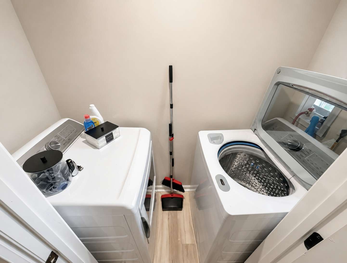 A compact laundry room with a washing machine, a dryer, and a small sink.
