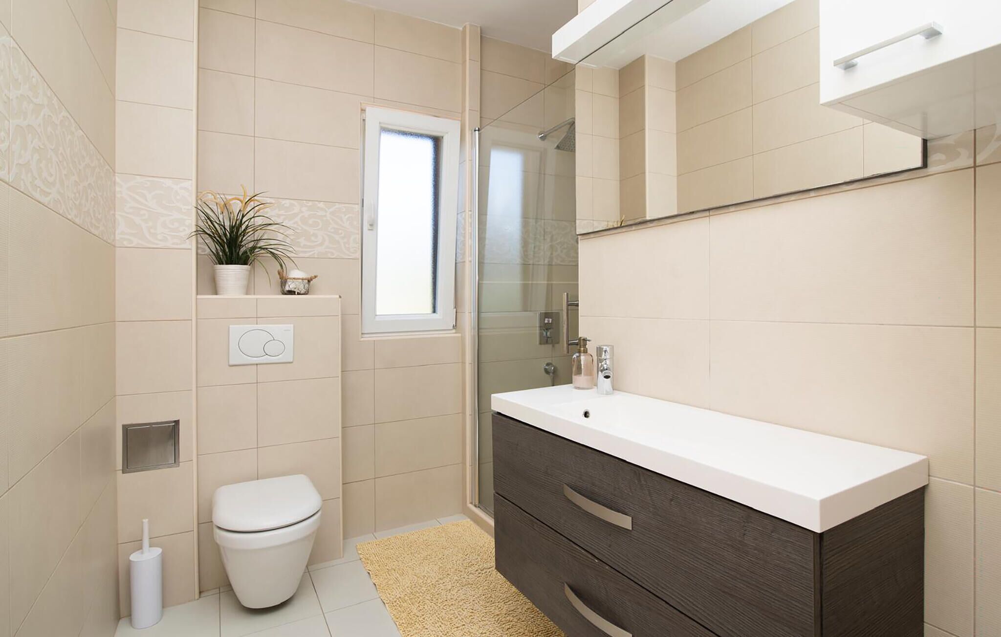 A modern bathroom with a toilet, sink, and shower.