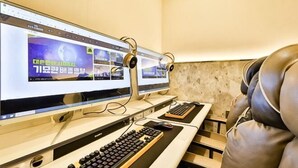 Et værelse med to computerskærme, et tastatur og et headset på et skrivebord.