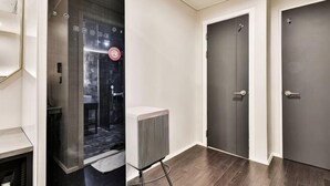 En gang med en glas elevator, en radiator og to mørke døre.