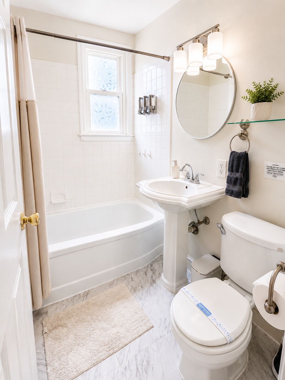 Une salle de bain avec une baignoire, un lavabo, des toilettes et un miroir.