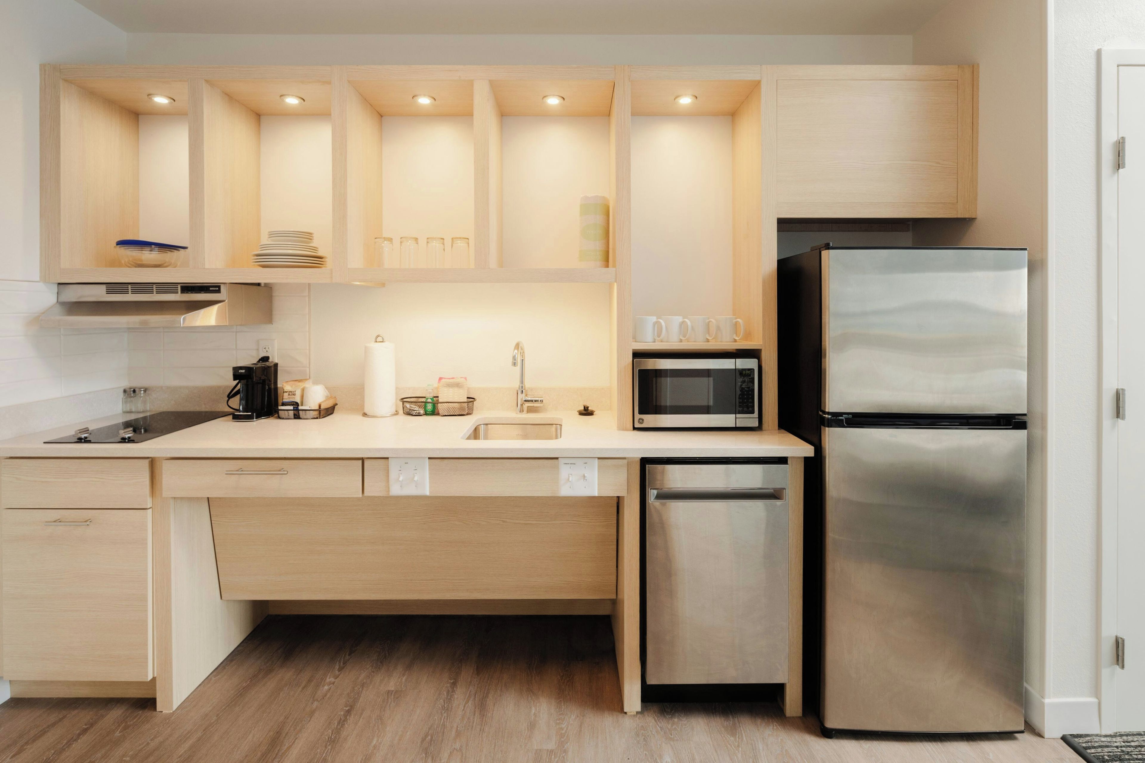 Una cocina compacta con electrodomésticos integrados, lavavajillas y microondas.