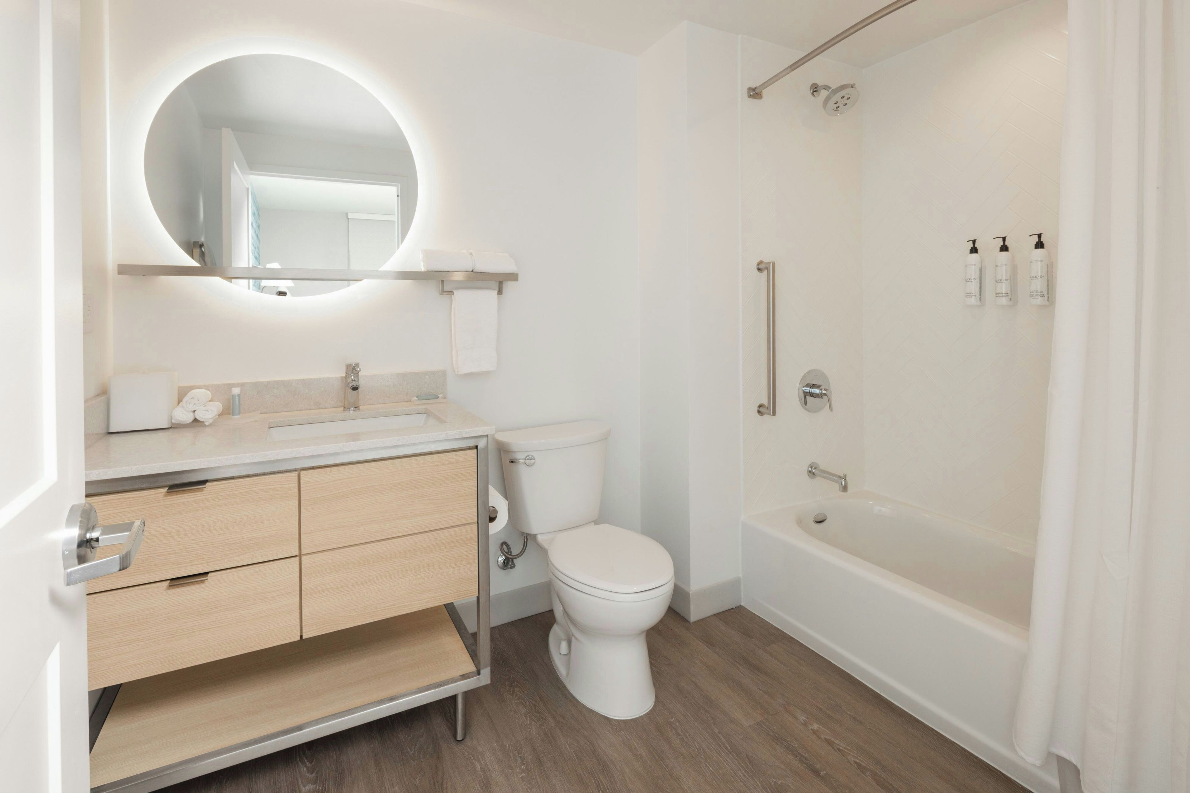 A modern bathroom with a toilet, sink, vanity, and a walk-in shower.