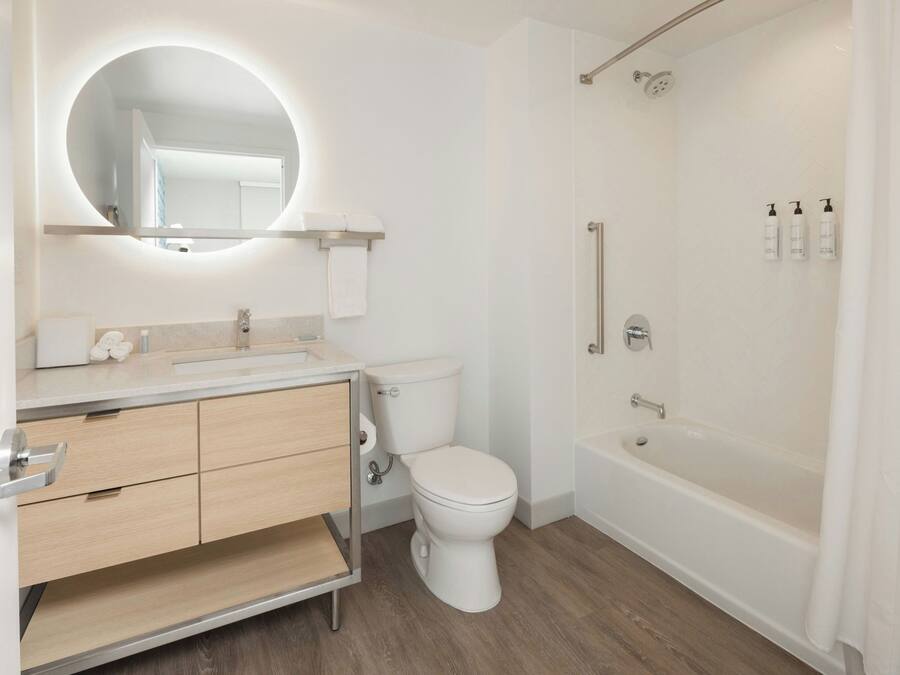 A modern bathroom with a toilet, sink, vanity, and a walk-in shower.