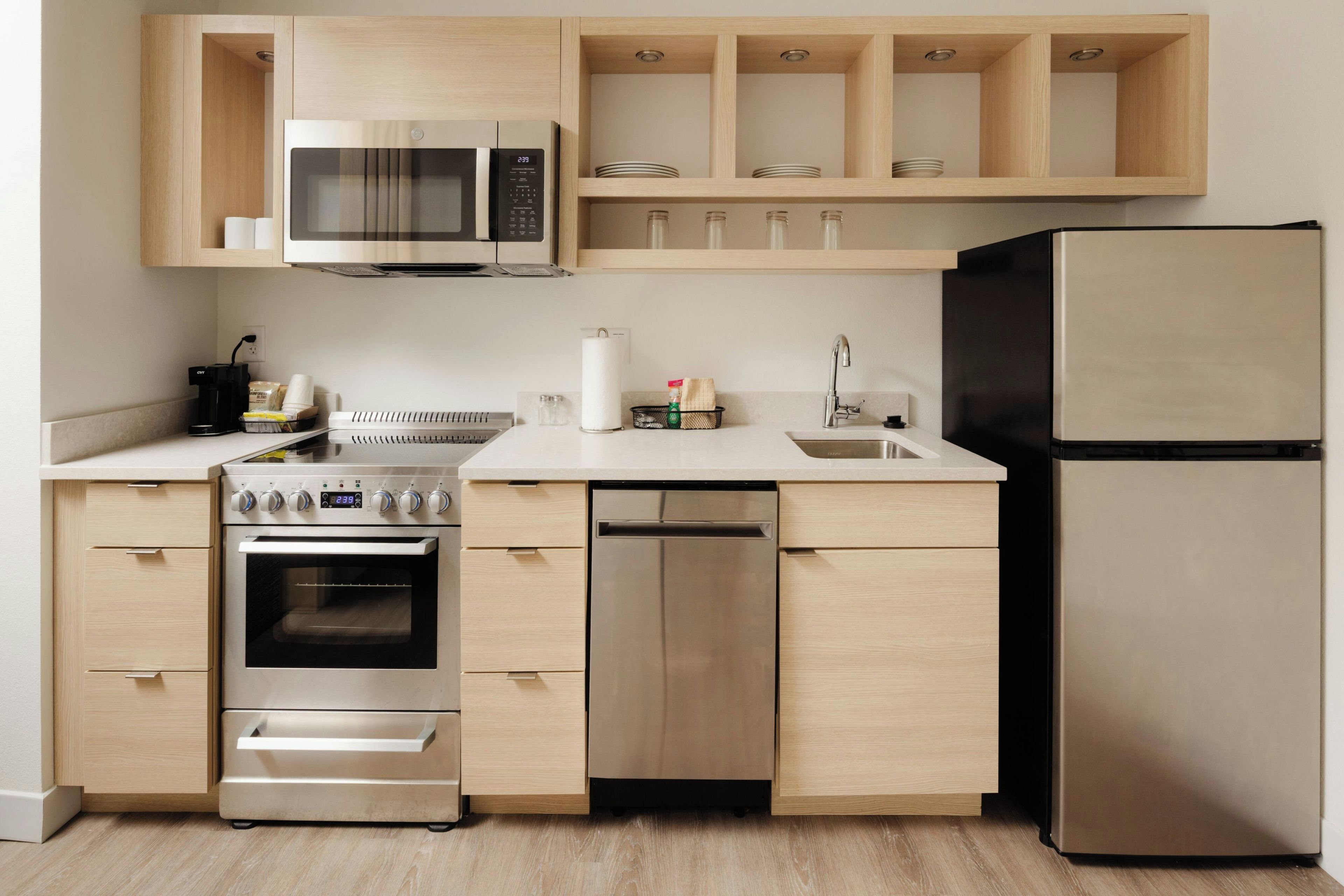 A modern kitchen with a built-in microwave, oven, dishwasher, and refrigerator.