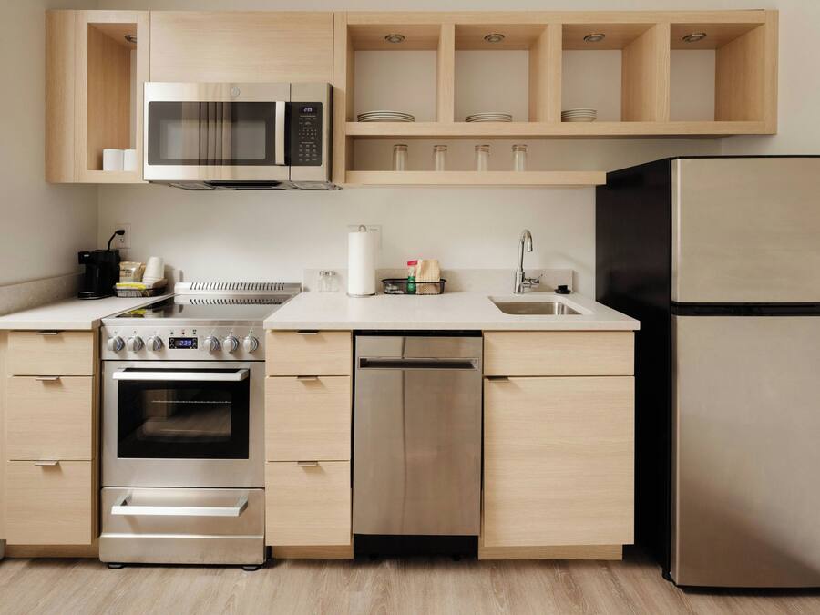 A modern kitchen with a built-in microwave, oven, dishwasher, and refrigerator.