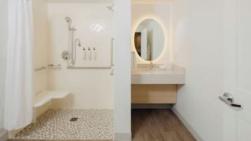 A modern bathroom with a shower, toilet, and sink.
