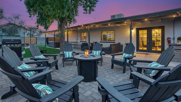 An outdoor patio with Adirondack chairs, a fire pit, and a barbecue grill. - Downtown Gilbert • Hot Tub • Glow Golf • Sleeps 12 (Gilbert)