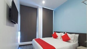 A modern hotel room with a large bed, a nightstand, and a TV mounted on the wall. - Hotel O Rg Motel (Temin)