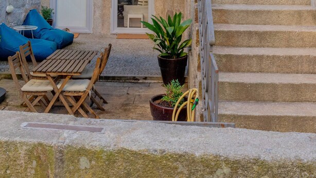 A stone staircase leading to a balcony with a metal railing. - VIVA República Serviced Apartment 0T (Porto)