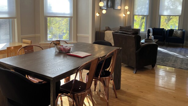 Un espace repas moderne avec une table en bois, des chaises et un panier rempli de collations.