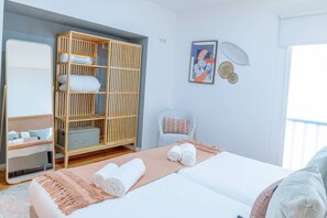 A bedroom with a bed, a wardrobe, a chair, and a bedside table. - VIVA República Serviced Apartment 2T (Porto)