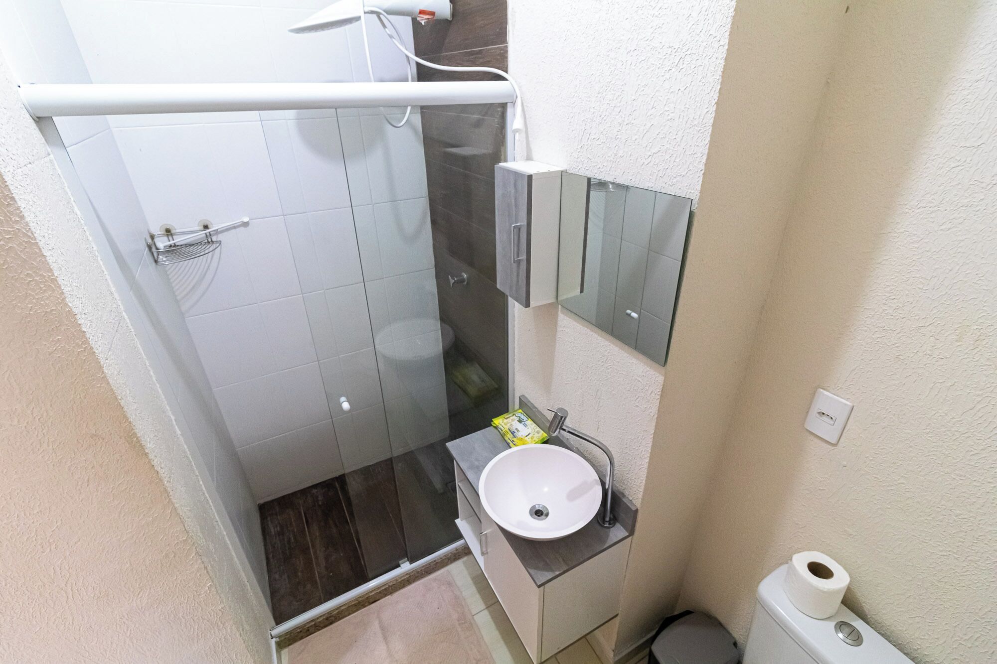 Un bagno piccolo e funzionale con doccia, lavandino e servizi igienici.