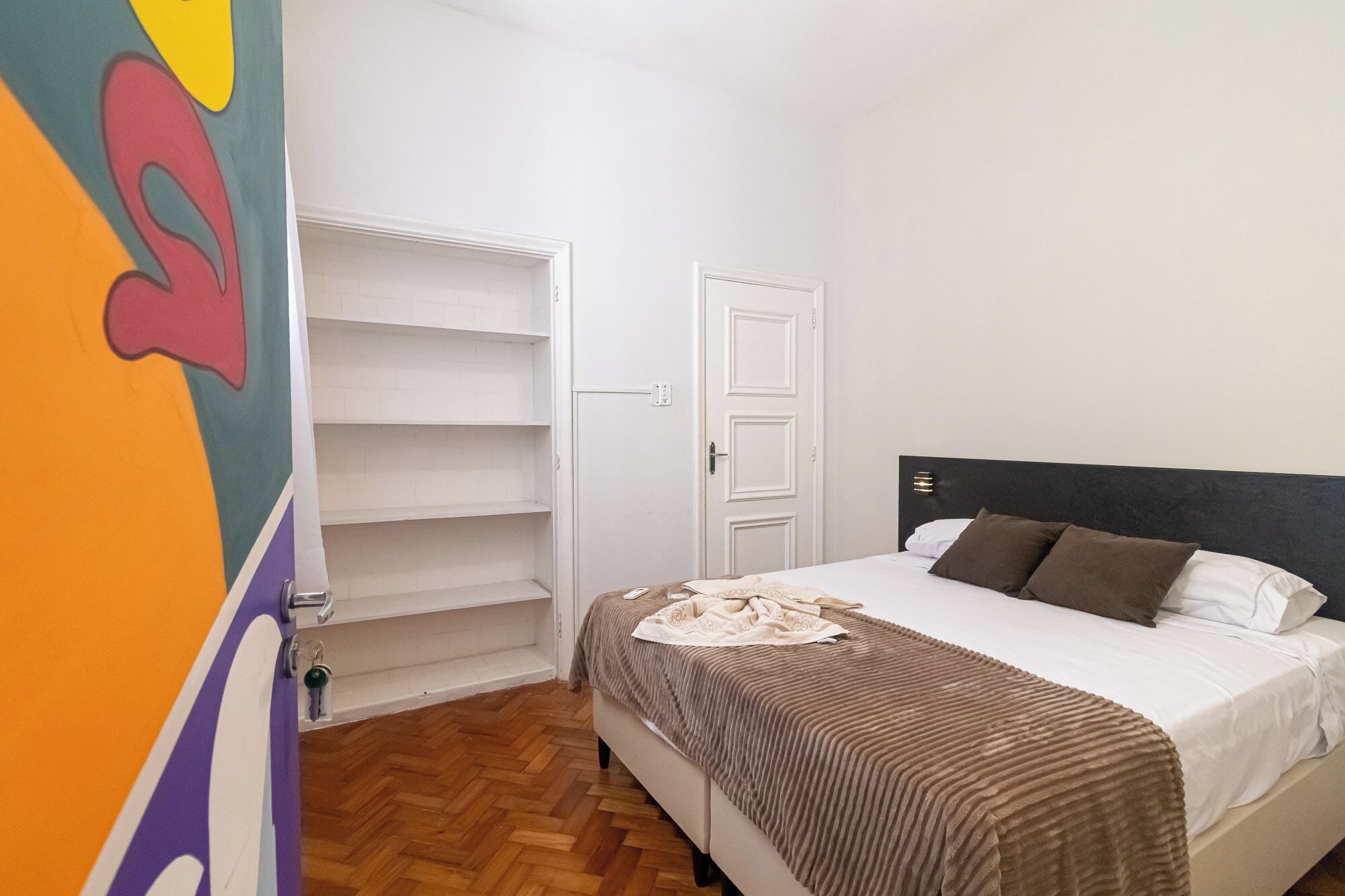 Une chambre à coucher avec un lit, une armoire et une porte.