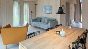 A dining area with a wooden table, chairs, and a sofa. - Beautiful home in Gilleleje with WiFi (Gilleleje)