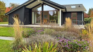 A modern two-story house with large glass windows and a covered porch. - Beautiful home in Gilleleje with WiFi (Gilleleje)