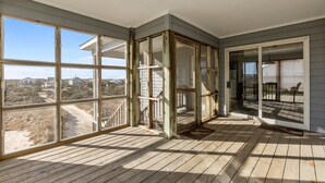 A spacious room with large windows, a wooden deck, and a view of the surrounding landscape. - 5854 - Erkkila. Relax at Erkkila, your perfect Outer Banks getaway near the beach. (Nags Head)