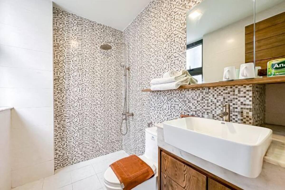 Ein Badezimmer mit Dusche, Toilette und einer großen Badewanne.