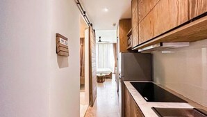 Une cuisine étroite avec des meubles en bois, une cuisinière encastrée et un évier.