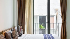 Une chambre à coucher avec un lit, des rideaux et une vue sur l’extérieur.