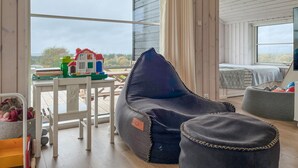 A cozy room with a bean bag chair, a small table with toys, and a bed with a view. - Awesome home in Store Fuglede with WiFi (Store Fuglede)