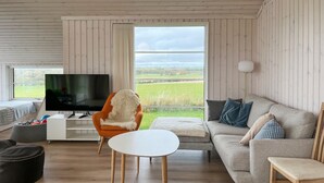 A modern living room with a television, a sofa, a chair, and a table. - Awesome home in Store Fuglede with WiFi (Store Fuglede)