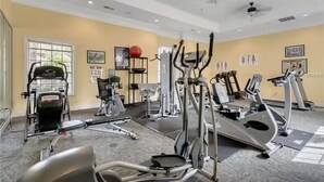 Ein Fitnessstudio mit unterschiedlichen Trainingsgeräten, darunter Laufbänder und Crosstrainer.