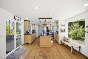 Una cocina moderna con armarios de madera, una isla central y vistas al exterior.