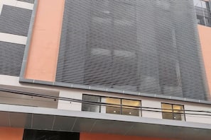 A building facade with horizontal slats, a flat roof, and a section with a window. - G Square Residences (Manila)