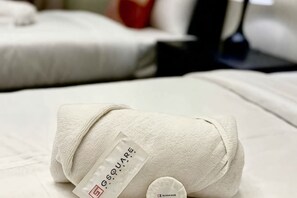 Ein ordentlich gefaltetes Handtuch mit einem Etikett auf einem Bett.