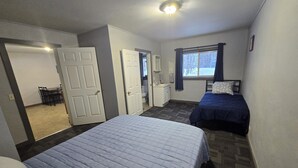 A room with two beds, a bathroom, and a dining area. - WP3 MTU & Keweenaw Base Full Kitchen + WiFi (Calumet)