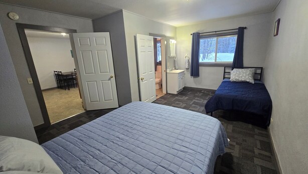 A hotel room with two beds, a bathroom, and a dining area. - WP3 MTU & Keweenaw Base Full Kitchen + WiFi (Calumet)