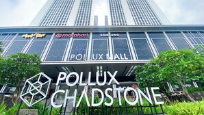 Ein modernes Gebäude mit großen Glasfenstern und Beschilderung für 'Pollux Mall' und 'Samsung'.