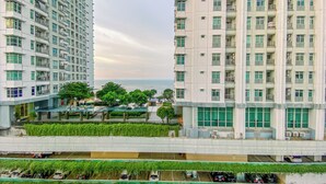 A high-rise residential building with multiple balconies, a rooftop garden, and a view of the sea. - Great Choice And Homey Studio Apartment At Tokyo Riverside Pik 2 (Teluknaga)