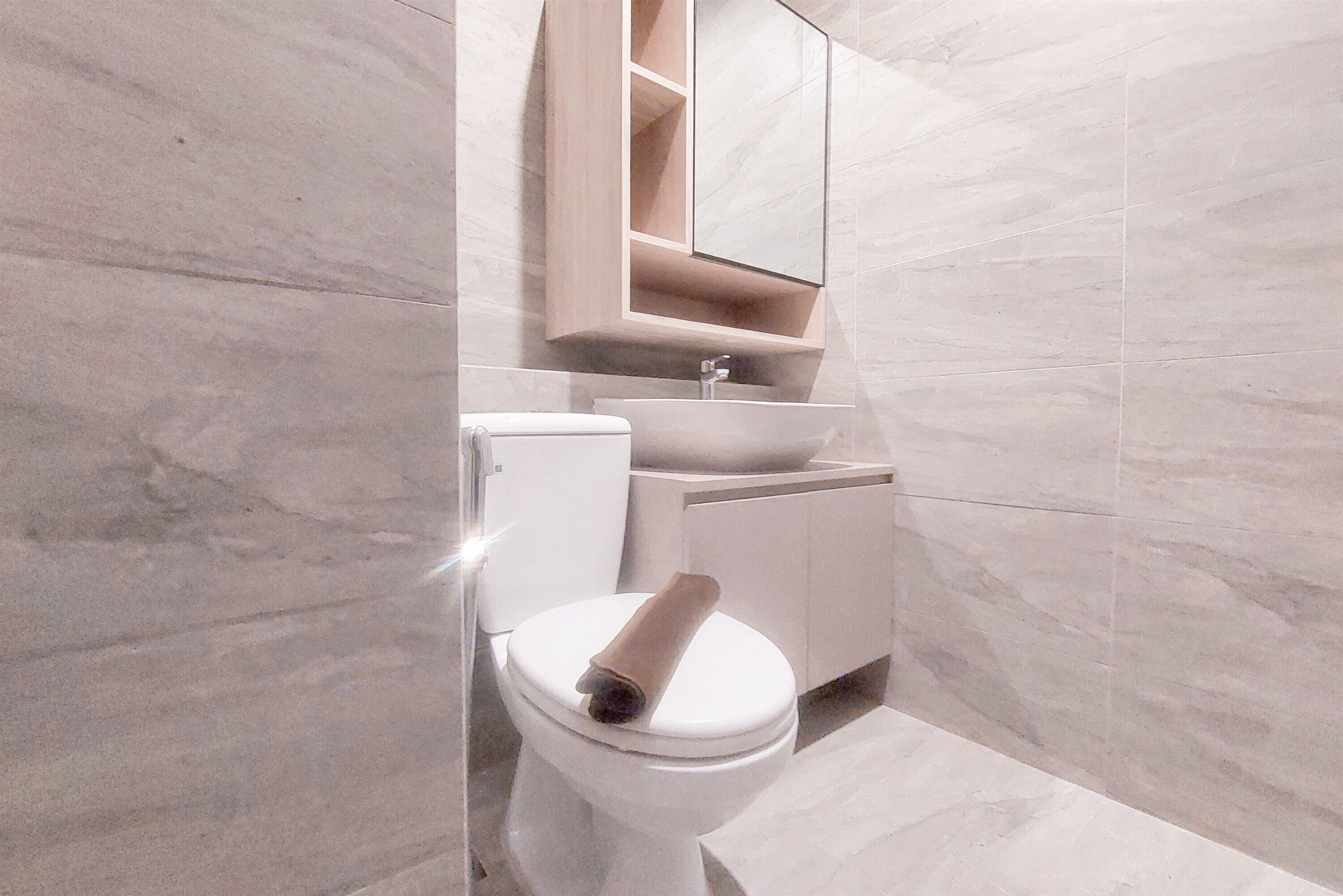 A modern bathroom with a toilet, sink, and mirror.