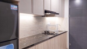 Eine Küche mit einem schwarzen Kühlschrank, einer Edelstahl-Spüle und einem Gasherd.