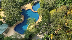 An aerial view of a landscaped area with a winding pool surrounded by dense greenery. - Good Location And Cozy 2Br Woodland Park Residence Apartment (Jakarta)