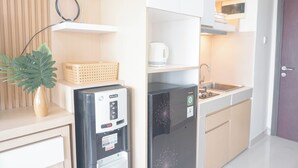 A compact kitchen with a refrigerator, microwave, and sink.