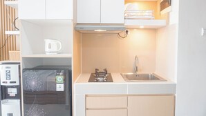 A compact kitchen with a built-in gas stove, a stainless steel sink, and a microwave.