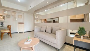Una sala de estar moderna con un sofá, una mesa de centro y un comedor con sillas.