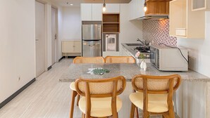 Una cocina moderna con una isla central, sillas de madera y un refrigerador integrado.