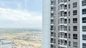 Ein Hochhaus mit mehreren Balkonen und Blick auf Stadt und Küste.
