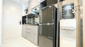 Eine moderne Küche mit einem Edelstahl-Kühlschrank, einem Wasserspender und einer Mikrowelle.