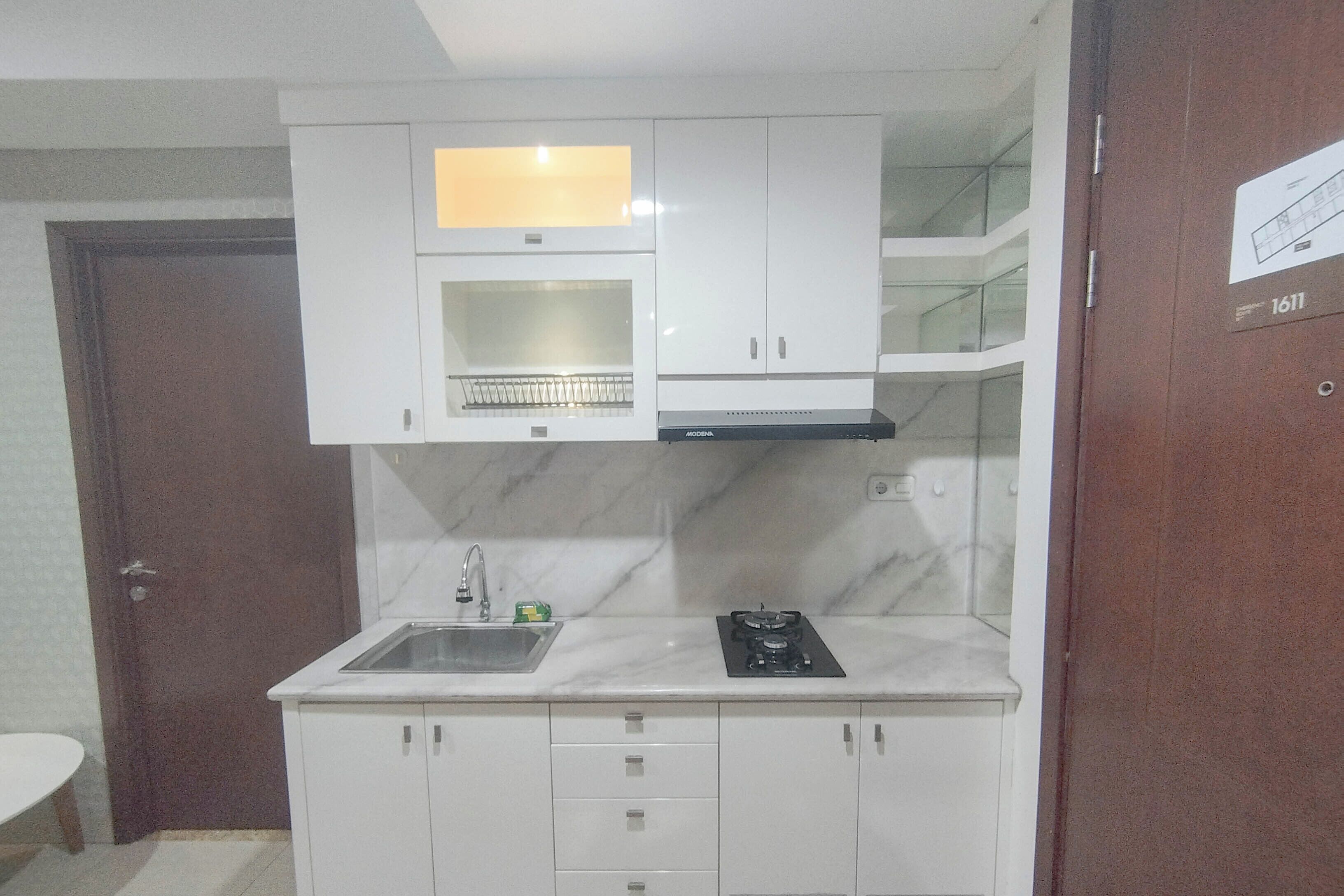 A compact kitchen with white cabinets, a built-in microwave, and a gas stove.