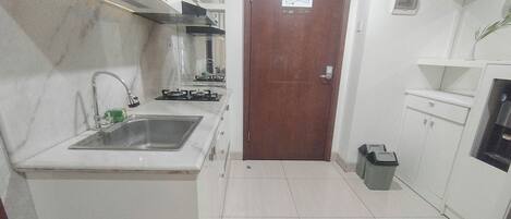 A compact kitchen with a sink, stove, and cabinets.