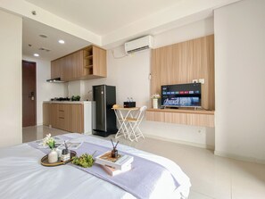 Cozinha moderna com armários de madeira, geladeira preta e área de refeições com mesa e cadeiras.
